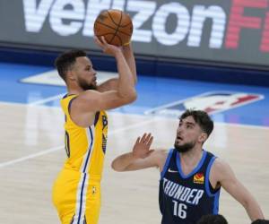 Stephen Curry, de los Warriors de Golden State, dispara frente a Ty Jerome, del Thunder de Oklahoma City. Foto:AP