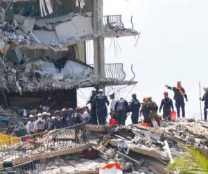 Rescatistas trabajan entre los escombros del condominio Champlain Towers South. Foto: AP