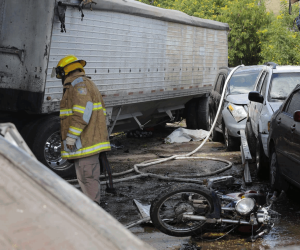 Un bombero entre los escombros que dejó el mortal choque de una rastra en El Carrizal.