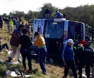 Rescatistas se reúnen alrededor del autobús volcado cerca de La Madrid, Argentina. Foto: AP.