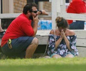 Una mujer reza en el césped afuera del gimnasio Alamo donde los padres esperan para reunirse con sus hijos después de un tiroteo en la escuela secundaria Santa Fe el viernes 18 de mayo de 2018 en Santa Fe, Texas. (Michael Ciaglo / Houston Chronicle vía AP).