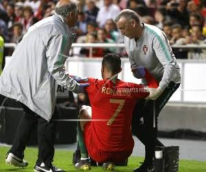 Cristiano Ronaldo, de la selección de Portugal, recibe ayuda del cuerpo médico durante un encuentro de la eliminatoria rumbo a la Eruocopa, el lunes 25 de marzo de 2019, ante Serbia, en Lisboa (AP Foto/Armando Franca).