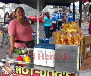 Una mujer vende comida en un carrito de hot dogs a la altura del bulevar Suyapa. Foto: Edwin Ordóñez/ EL HERALDO.