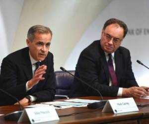 El gobernador del Banco de Inglaterra, Mark Carney, izquierda, y el gobernador designado Andrew Bailey explican medidas tomadas para mitigar el impacto del coronavirus en la economía, en el Banco de Inglaterra, Londres, miércoles 11 de marzo de 2020. AP.