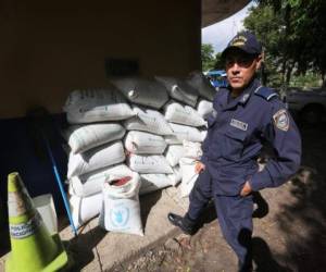 Un agente de la Policía Nacional reguarda varios sacos de frijoles decomisados en la salida a Olancho. (Fotos: Antonio Mendoza)