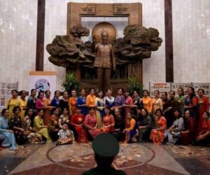 Turistas posan frente a la estatua del líder revolucionario Ho Chi Minh. Foto: AFP.