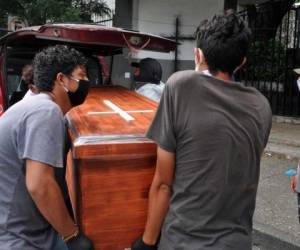 Relatives of a person who died from the new coronavirus unload the wrapped coffin from a truck outside a cemetery in the north of Guayaquil, Ecuador on April 17, 2020. (Photo by Jose Sanchez LINDAO / AFP)