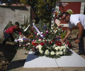 Juan, a la derecha, detenido en conexión con la desaparición y asesinato de Marbella Valdez, coloca una corona de flores sobre su tumba, junto al exnovio de la joven, Jairo Solano, durante su fineral en un cementerio de Tijuana. Foto: AP.