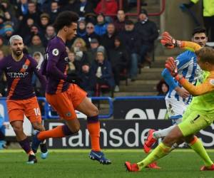 Leroy Sané rematando ante Jonas Lossl en el duelo Manchester City vs Huddersfield. En el fondo se observa al Kun Agüero. (AFP)