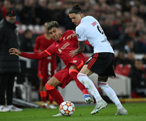 El centrocampista brasileño del Liverpool Roberto Firmino (izq.) lucha por el balón con el delantero uruguayo del Benfica Darwin Núñez durante el partido de fútbol de vuelta de los cuartos de final de la UEFA Champions League entre el Liverpool y el Benfica en el estadio de Anfield.