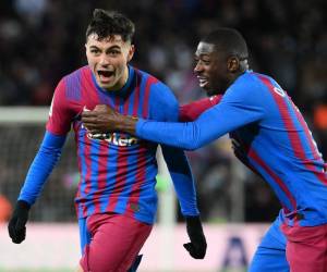 El centrocampista español del Barcelona Pedri celebra marcar el gol inicial con el delantero francés del Barcelona Ousmane Dembele (D) durante el partido de fútbol de la Liga española entre el FC Barcelona y el Sevilla FC en el estadio Camp Nou de Barcelona el 3 de abril de 2022.