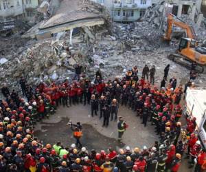 Los socorristas se abrazan mientras se reúnen para brindar respeto por las víctimas del terremoto del viernes antes de que la misión de búsqueda y rescate fuera formalmente suspendida. Foto: AP.