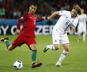 Cristiano Ronaldo de Portugal protege el balón ante la marca de Birkir Bjarnason (Foto: AFP)