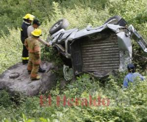 Bomberos analizan cómo sacar los cuerpos atrapados en el carro. Fotos: Jhonny Magallanes/ El Heraldo Honduras.