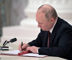 El presidente ruso Vladimir Putin firma documentos, incluido un decreto que reconoce como independientes a dos regiones separatistas respaldadas por Rusia en el este de Ucrania, durante una ceremonia en el Kremlin en Moscú.