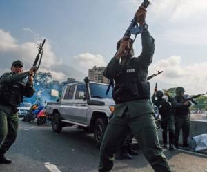 Los miembros de la Guardia Nacional Bolivariana que se unieron al líder opositor venezolano y al autoproclamado presidente Juan Guaido dispararon al aire para repeler a las fuerzas leales al presidente Nicolás Maduro que llegó para dispersar una manifestación cerca de la base militar La Carlota en Caracas el 30 de abril de 2019. Foto: Agencia AFP.