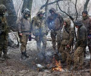 Soldados intentan recibir calor por medio de una fogata en medio de un invierno agresivo durante la guerra entre Rusia y Ucrania.