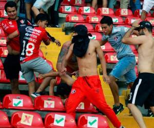 Simpatizantes del Atlas se pelean con aficionados del Querétaro durante el partido de fútbol del torneo Clausura mexicano entre el Querétaro y el Atlas en el estadio Corregidora en Querétaro, México, el 5 de marzo de 2022.