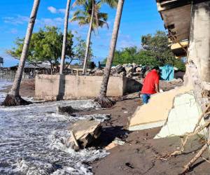 Un hombre camina por viviendas destruidas en la costa de Cedeño, una comunidad de Honduras que cada año es devorada por el mar.