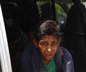 A Central American migrant - part of a group of mostly Hondurans travelling on caravan to the US- is detained by a member of Mexico's National Guard after crossing the Suichate River, the natural border between, Guatemala, with Ciudad Hidalgo, Mexico, on January 20, 2020. - Hundreds of Central Americans from a new migrant caravan tried to enter Mexico by force Monday by crossing the river that divides the country from Guatemala, prompting the National Guard to fire tear gas, an AFP correspondent said. (Photo by ISAAC GUZMAN / AFP)