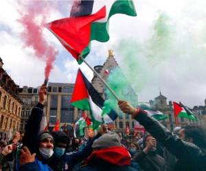 Unas personas sostienen banderas palestinas y bengalas durante una protesta en Lille, en el norte de Francia, el sábado 15 de mayo de 2021.