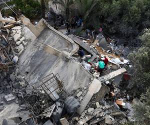 Los palestinos inspeccionan los escombros de un edificio, luego de un ataque aéreo israelí, en Beit Lahia, en el norte de la Franja de Gaza.