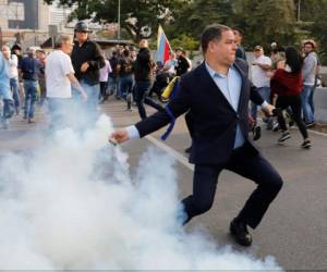 Un oponente del presidente de Venezuela, Nicolás Maduro, devuelve un recipiente de gas lacrimógeno en Caracas, Venezuela, el lunes 29 de abril de 2019.