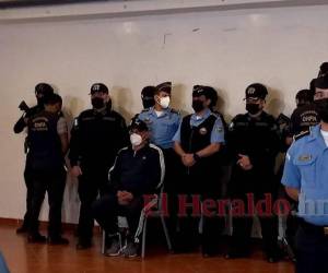 Con esposas en sus manos y cadenas en sus pies fue presentado la noche del miércoles el exjefe de la Policía Nacional, Juan Carlos “El Tigre” Bonilla, en la Secretaría de Seguridad, tras ser detenido más temprano en el peaje de Zambrano, carretera CA-5 que conduce al norte de Honduras.