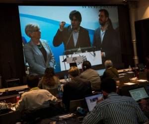 El expresidente regional de Cataluña Carles Puigdemont aparece en pantalla durante una videoconferencia desde Bruselas, en la sede del partido en Barcelona, España. Foto: Agencia AP / Emilio Morenatti