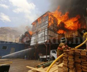 Las inmensas llamas consumieron en instantes la fábrica. Los bomberos lucharon por detenerlas. Foto: Estalín Irías / El Heraldo.