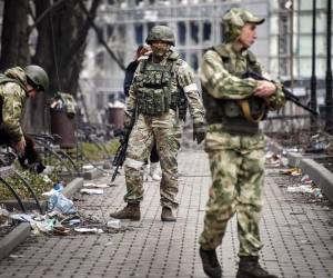 Soldados rusos caminan por una calle en Mariupol el 12 de abril de 2022, mientras las tropas rusas intensifican una campaña para tomar la ciudad portuaria estratégica, parte de un ataque masivo anticipado en el este de Ucrania, mientras el presidente de Rusia presenta un caso desafiante para la guerra contra el vecino de Rusia.