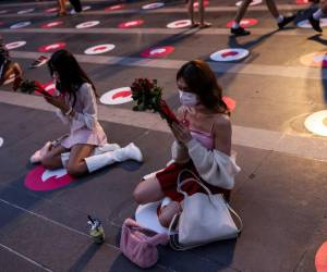 La gente reza con rosas rojas en el Santuario Trimurti, que se cree trae amor a quienes adoran ante él, en Bangkok el Día de San Valentín.