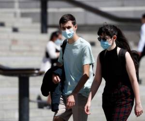 Dos personas caminan por la Plaza Trafalgar el jueves 30 de julio de 2020 portando mascarillas para protegerse del coronavirus, en Londres.