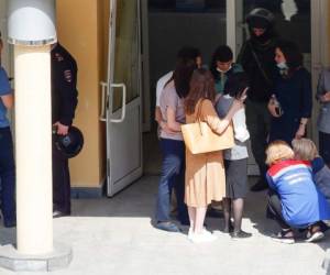 Un psicólogo consuela a una mujer en el lugar de un tiroteo en la escuela No. 175 en Kazán, la capital de la república rusa de Tartaristán, el 11 de mayo de 2021. Foto: AFP