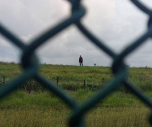 Jimmy Muñoz, un ecuatoriano de 29 años, logró entrar pero tiene frente a él un alambrado de púas y la valla de unos 4 metros de alto.