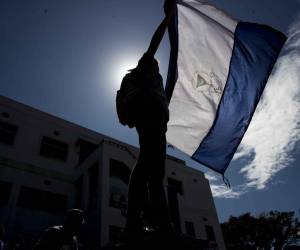 Fotografía de archivo en donde una joven sostiene una bandera nicaragüense.