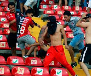 Los seguidores de Atlas pelean con los seguidores de Querétaro durante el partido de fútbol del torneo Clausura mexicano entre Querétaro y Atlas en el estadio Corregidora en Querétaro, México.