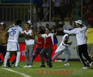 Jhonatan Ferrari, defensor del Olimpia, intentó controlar la situación cuando los aficionados del Olimpia ingresaron a la cancha del Nacional. Foto: EL HERALDO