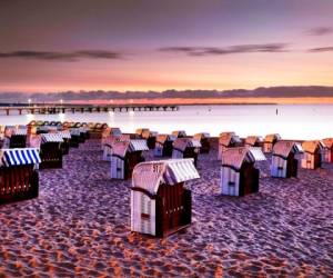 En esta imagen del 21 de agosto de 2018, se ven sillas de playa alineadas antes del amanecer en Timmendorfer Strand en el Mar Báltico, al norte de Alemania. AP.