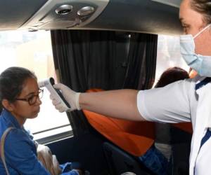 TOPSHOT - A health worker takes samples from a stall vendor to test her for COVID-19 coronavirus, at The Terminal market in Guatemala City on May 21, 2020. (Photo by Johan ORDONEZ / AFP)