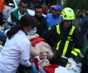 An injured woman is evacuated on a gurney after an explosion at the Centro Andino shopping center in Bogota, Colombia, Saturday, June 17, 2017. Authorities reported at least 3 persons killed with scores more injured. (AP Photo/Ricardo Mazalan)