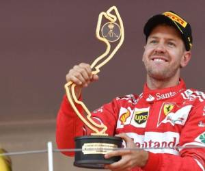 Sebastian Vettel sostiene su trofeo mientras celebra en el podio después de ganar en Mónaco (Foto: Agencia AFP)