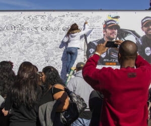 Fans crowd the scene of a memorial rally and car cruise in Valencia, Calif., Sunday, Dec. 8, 2013 to remember actor Paul Walker and his friend Roger Rodas, who died in a fiery car crash last Saturday. (AP Photo/Ringo H.W. Chiu)