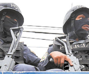 National Police agents look for members of the gang Mara 18 in a south area of Tegucigalpa on June 14, 2012. Tegucigalpa and Honduran northern city of San Pedro Sula, are among the most dangerous cities in the world with at least 119 homicides every 100 thousand inhabitants, according to civil organizations. AFP PHOTO/Orlando SIERRA