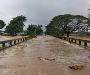 Este martes varios ríos rebasaron los puentes en los ejes carreteros. Imagen del puente ubibcado sobre el río Tocoa, en Colón.