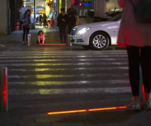 Un niño israelí juega con una luz led en un cruce en Tel Aviv, Israel. Tel Aviv ha empotrado las ledes para proteger a los peatones distraídos por sus teléfonos celulares. (Foto: AP)