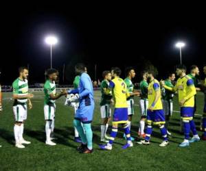 El arquero camerunés Vlery Pajetat y los demás jugadores del Haringey, saludan a sus rivales del Yeovil, antes de un partido eliminatorio para la Copa de la FA, el martes 29 de octubre de 2019. El encuentro original se canceló el 19 de septiembre, por insultos racistas a Pajetat y a otro jugador (Steven Paston/PA via AP)