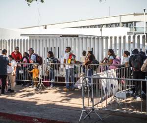 Migrantes hacen fila en la garita el Chaparral para cruzar la frontera hacia Estados Unidos, en la ciudad de Tijuana, en Baja California.