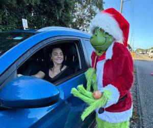 El coronel Lou Caputo, de la Oficina del Alguacil del Condado de Monroe, disfrazado de ‘Grinch’, ofrece una cebolla a una conductora que iba ligeramente con exceso de velocidad en una zona escolar este jueves.