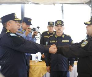 El comisionado David Leonardo Ortega Pagoaga (izquierda) recibe el bastón de mando del comisionado general Mario Molina Moncada, que lo acredita como nuevo director de la Dipampco.